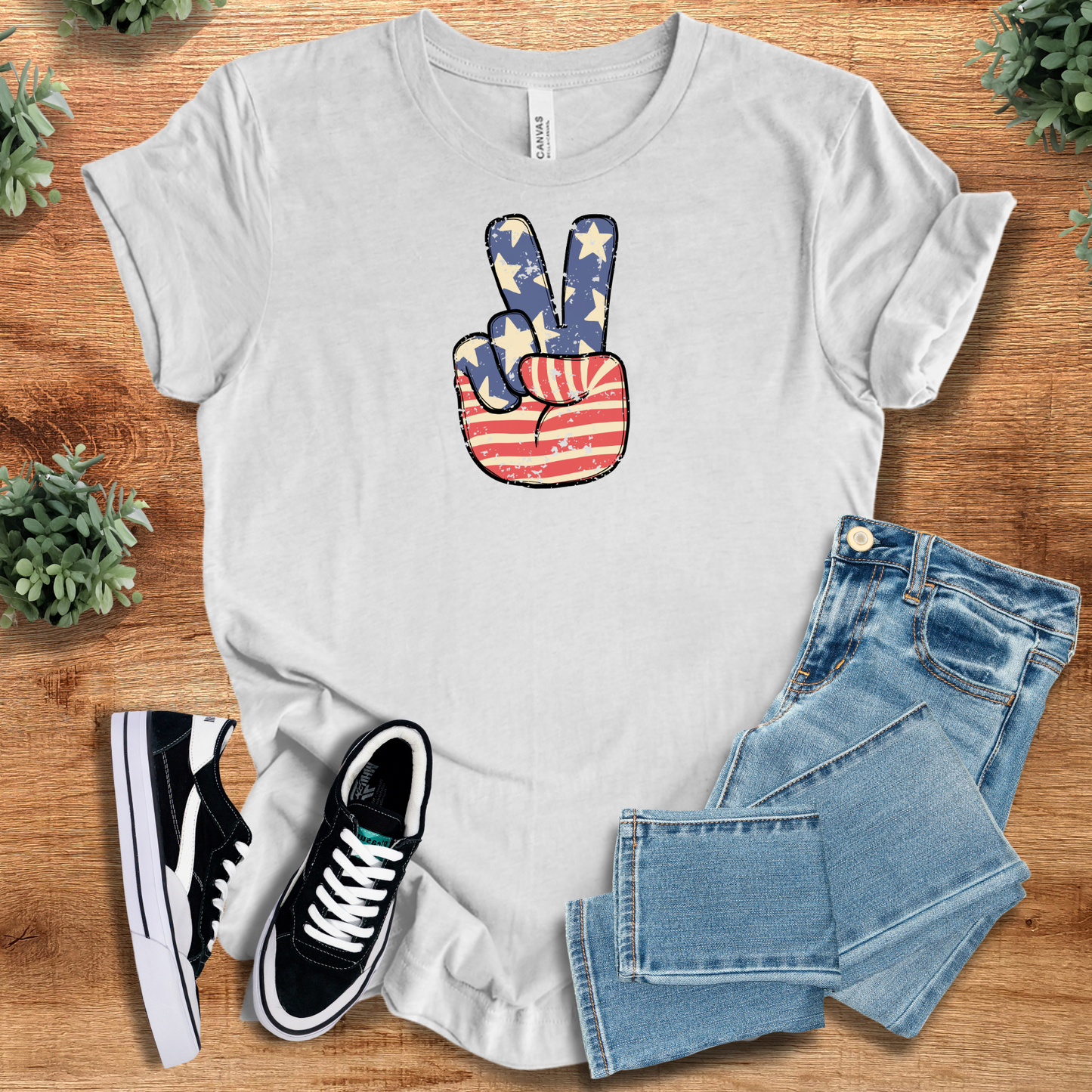 Ash t-shirt with '' text, flat lay styled on a wooden surface.