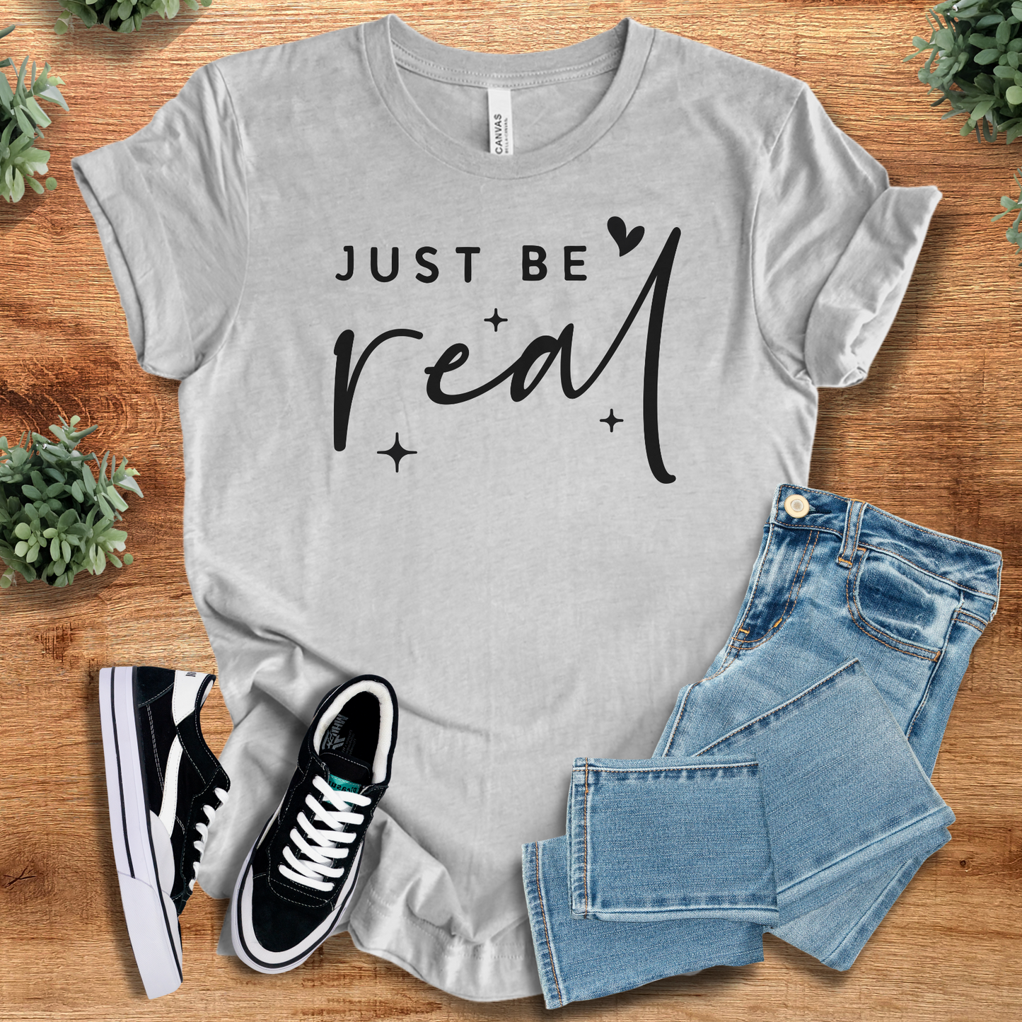 Heather-aqua t-shirt with '' text, flat lay styled on a wooden surface.