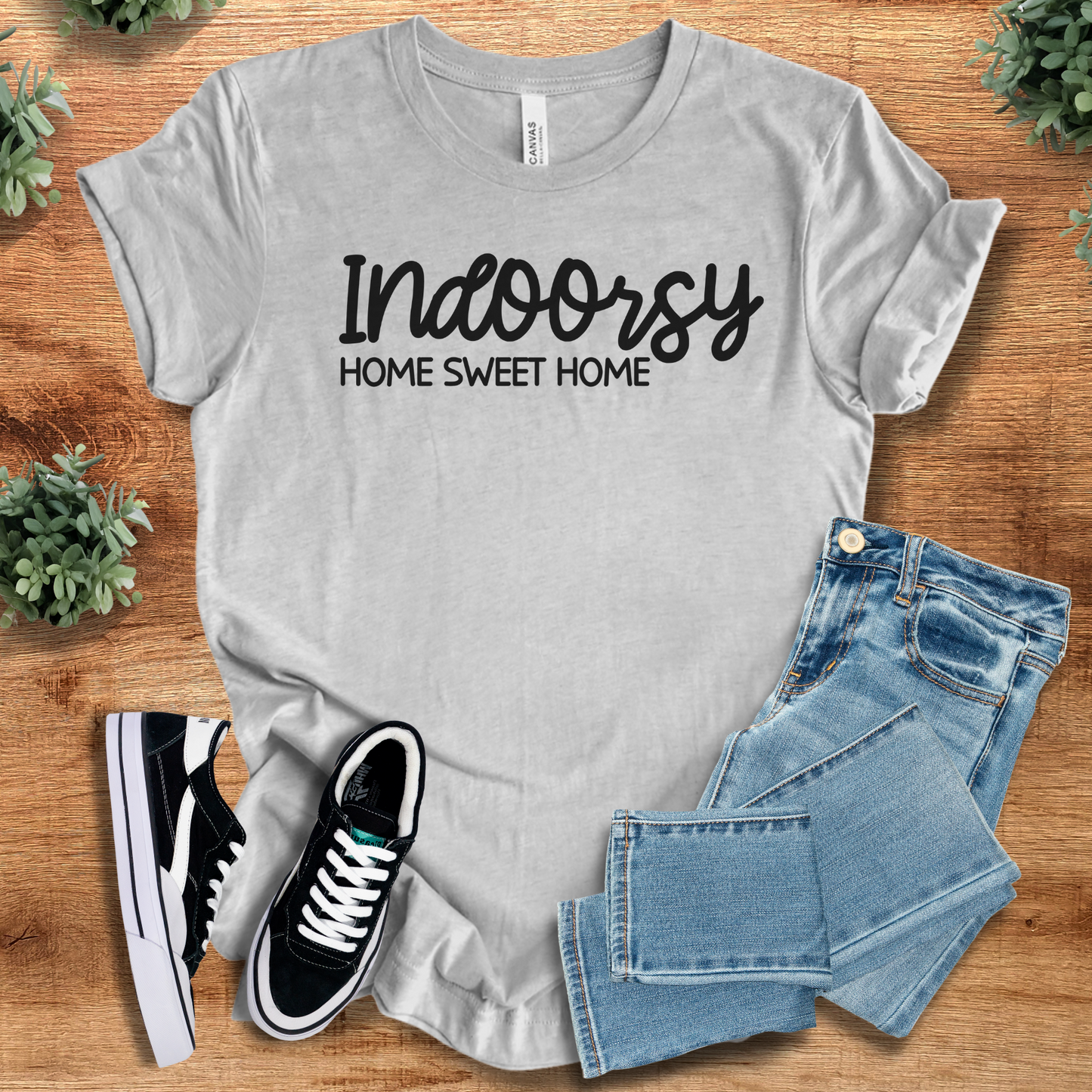 Heather-aqua t-shirt with '' text, flat lay styled on a wooden surface.