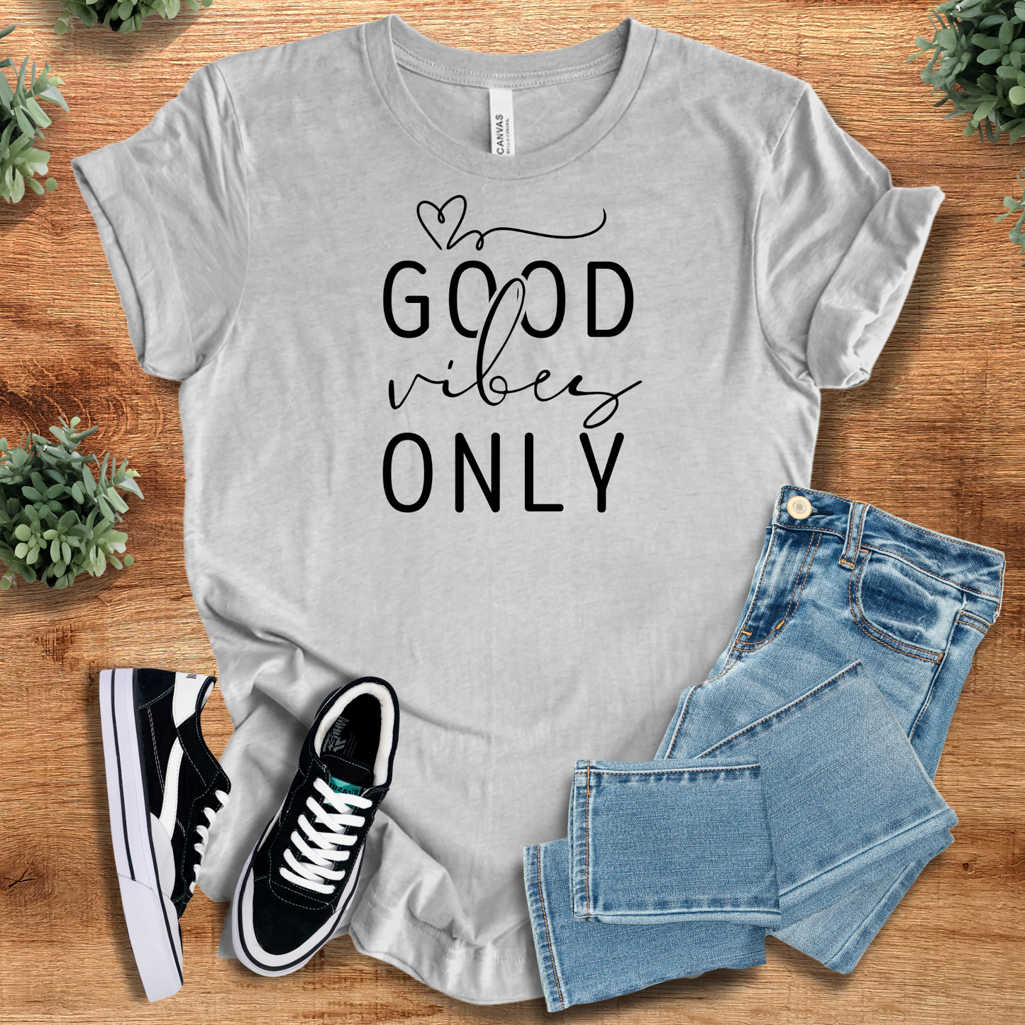 Heather-navy t-shirt with '' text, flat lay styled on a wooden surface.