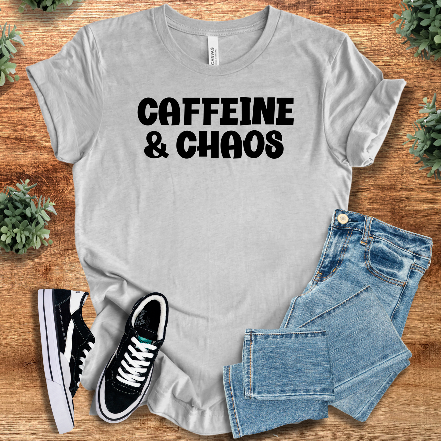 Black t-shirt with '' text, flat lay styled on a wooden surface.