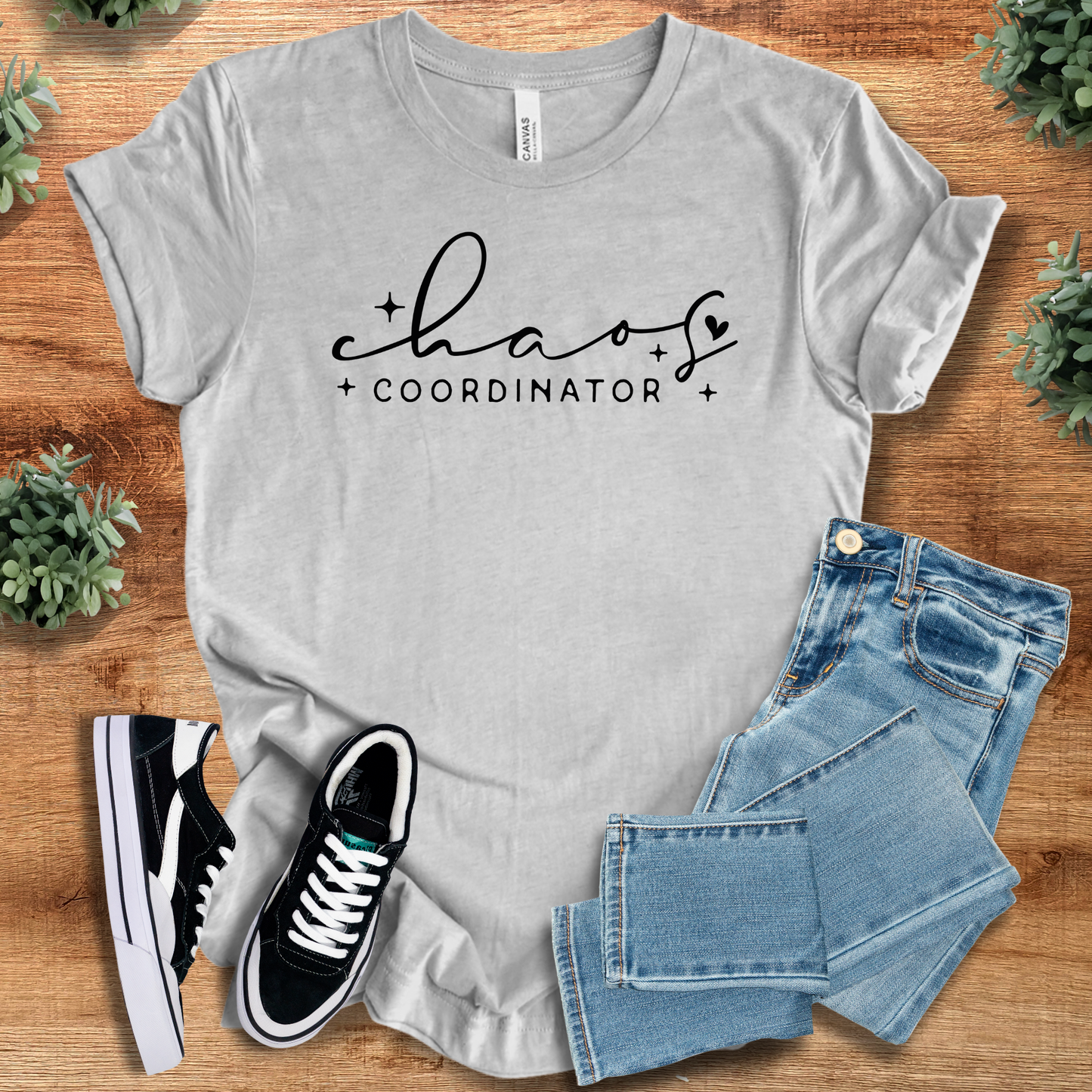 Athletic-heather t-shirt with 'Chaos Coordinator Tee T‑Shirt' text, flat lay styled on a wooden surface.
