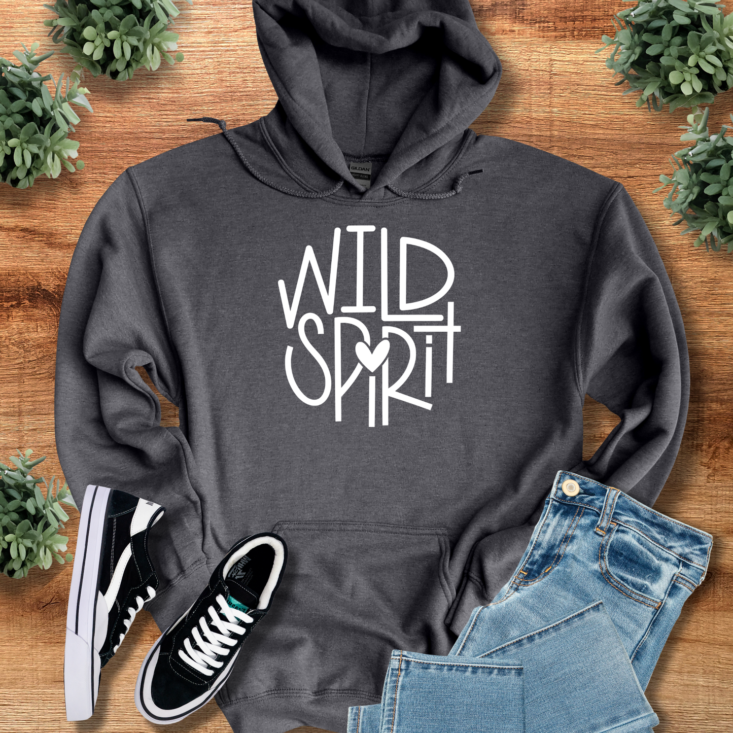 Wild Spirit Hoodie for outdoor and casual wear in dark gray with bold white graphic text, styled with denim shorts and black sneakers.