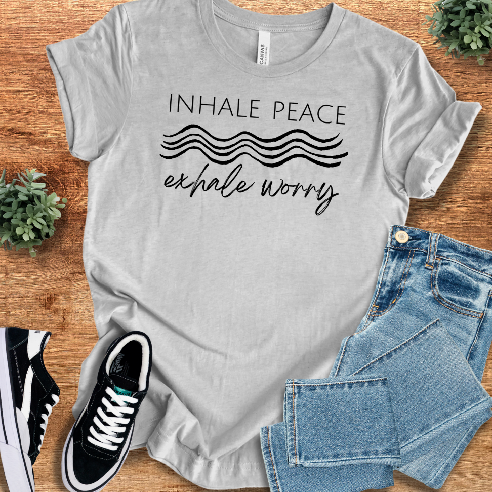 Heather-aqua t-shirt with '' text, flat lay styled on a wooden surface.