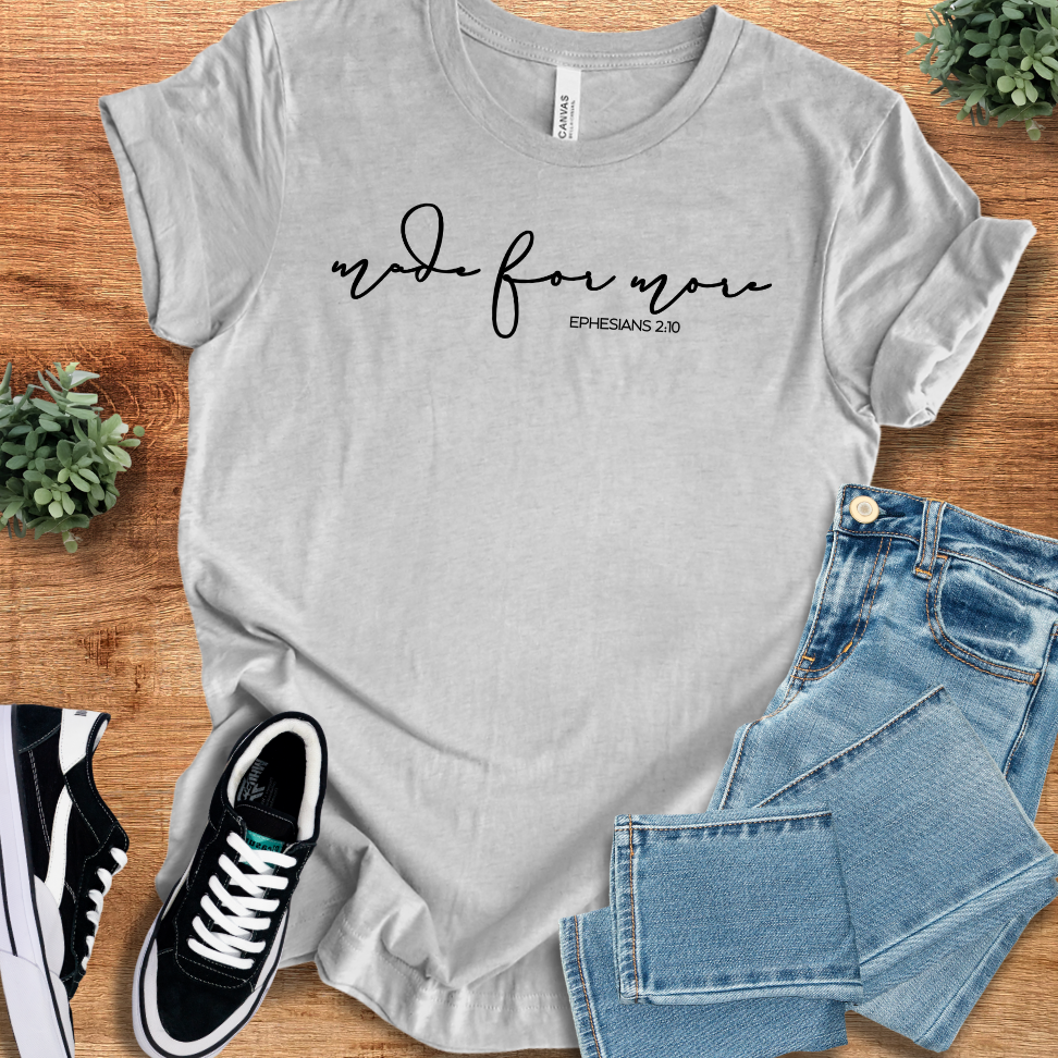 Heather-mauve t-shirt with '' text, flat lay styled on a wooden surface.