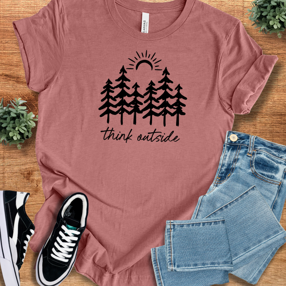 Heather-mauve t-shirt with '' text, flat lay styled on a wooden surface.