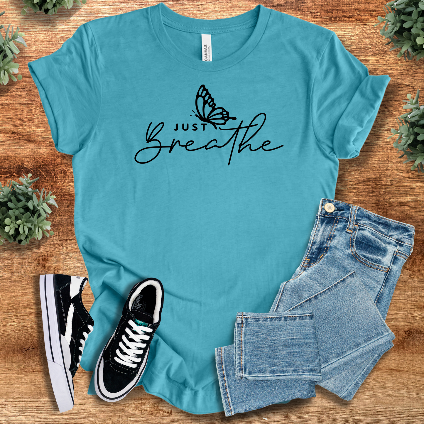 Aqua blue Just Breathe Tee T‑Shirt on soft Bella+Canvas 3001, nature-inspired graphic tee styled with jeans and sneakers.
