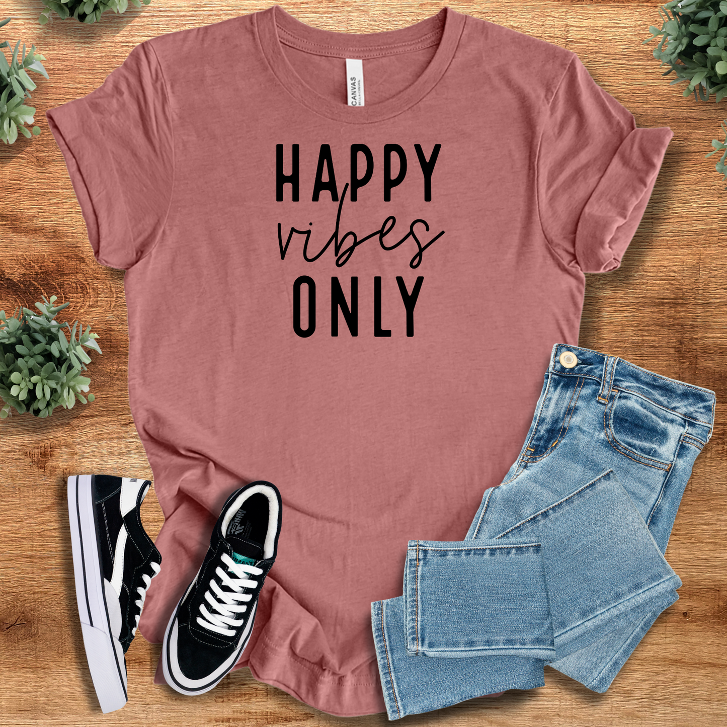Happy Vibes Only Tee in mauve with black text, styled with jeans and sneakers. Airlume cotton positive vibes t-shirt for cheerful everyday wear.