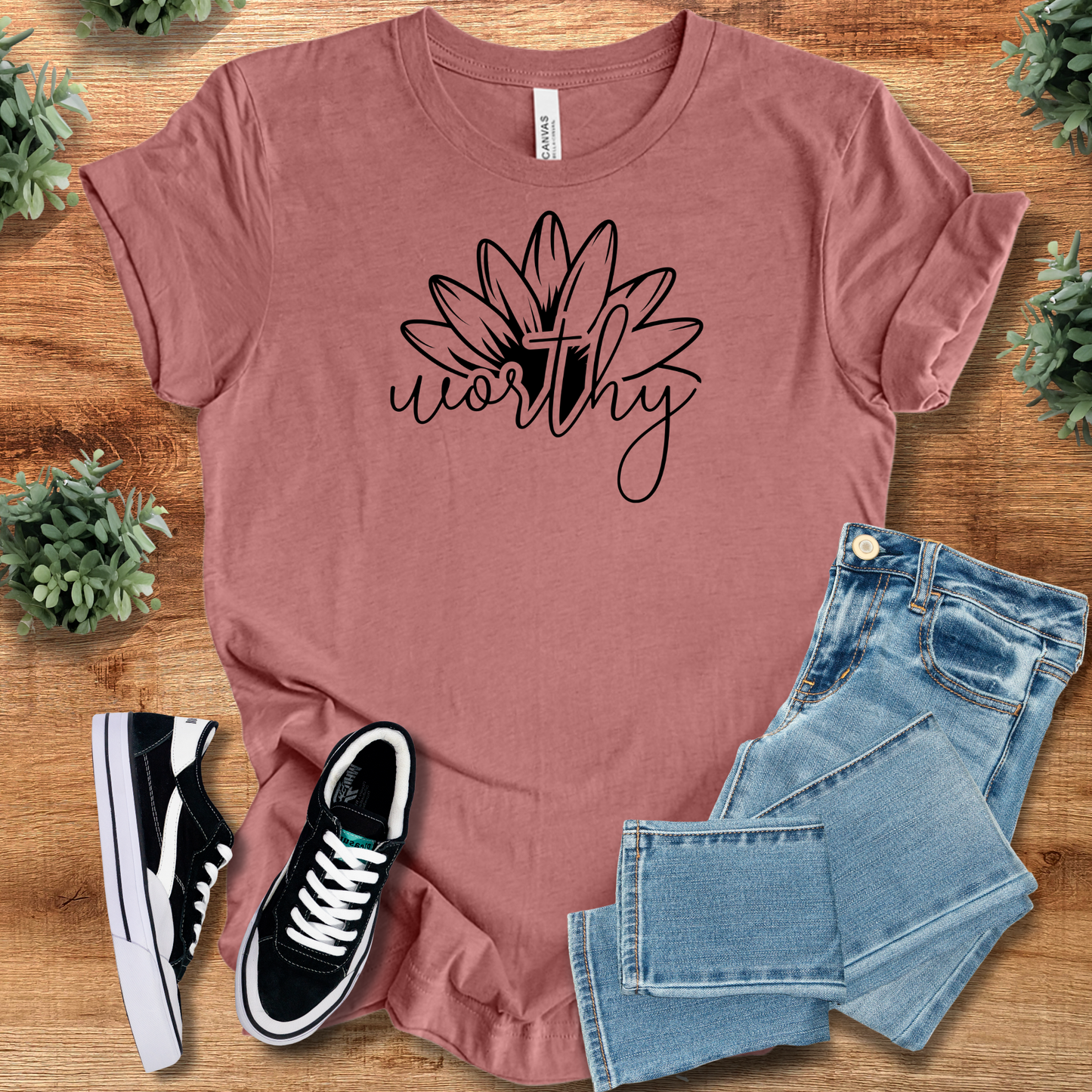 Heather-aqua t-shirt with '' text, flat lay styled on a wooden surface.