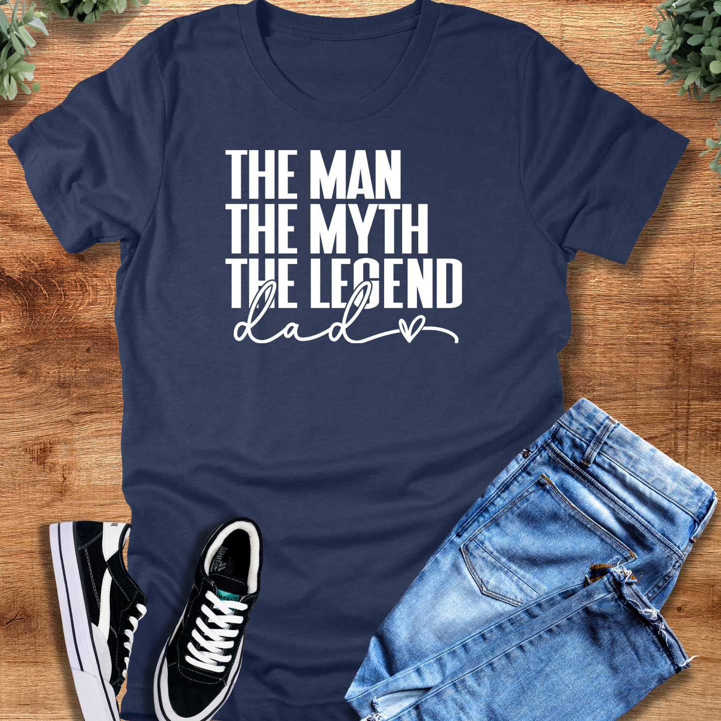 Black t-shirt with '' text, flat lay styled on a wooden surface.