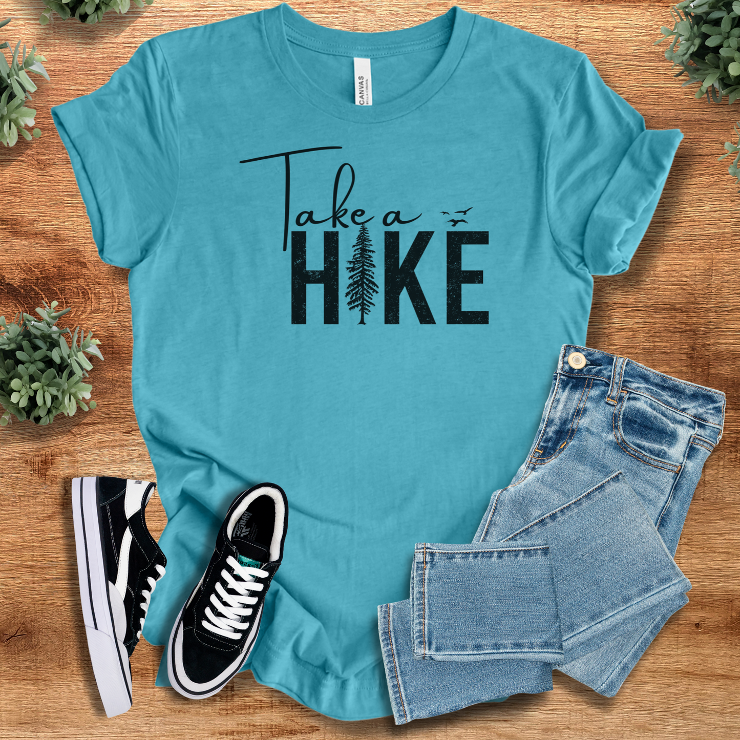Heather-navy t-shirt with '' text, flat lay styled on a wooden surface.