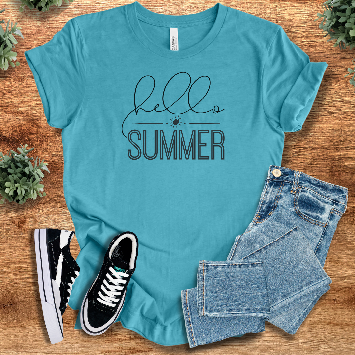 Yellow t-shirt with '' text, flat lay styled on a wooden surface.