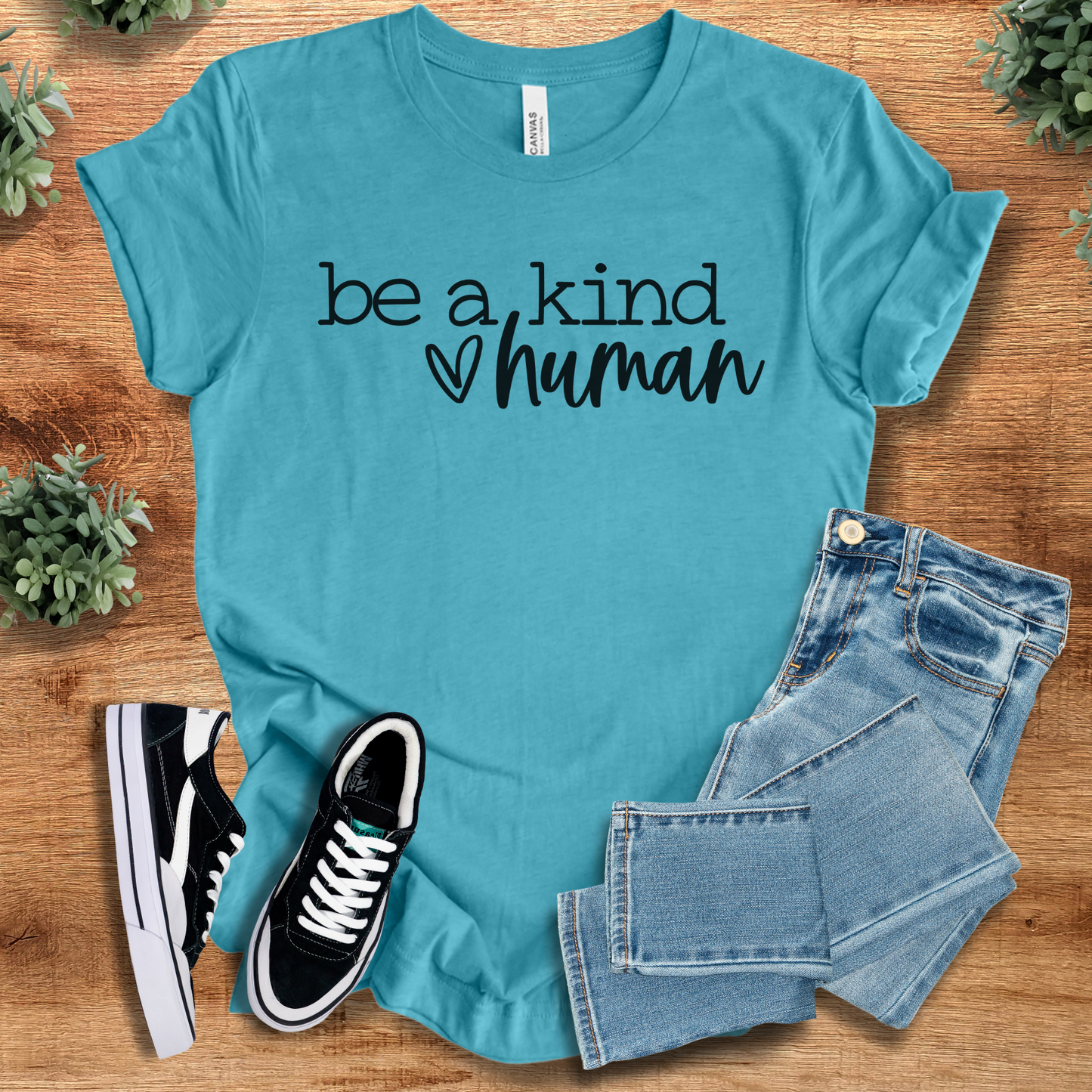 Heather-navy t-shirt with '' text, flat lay styled on a wooden surface.