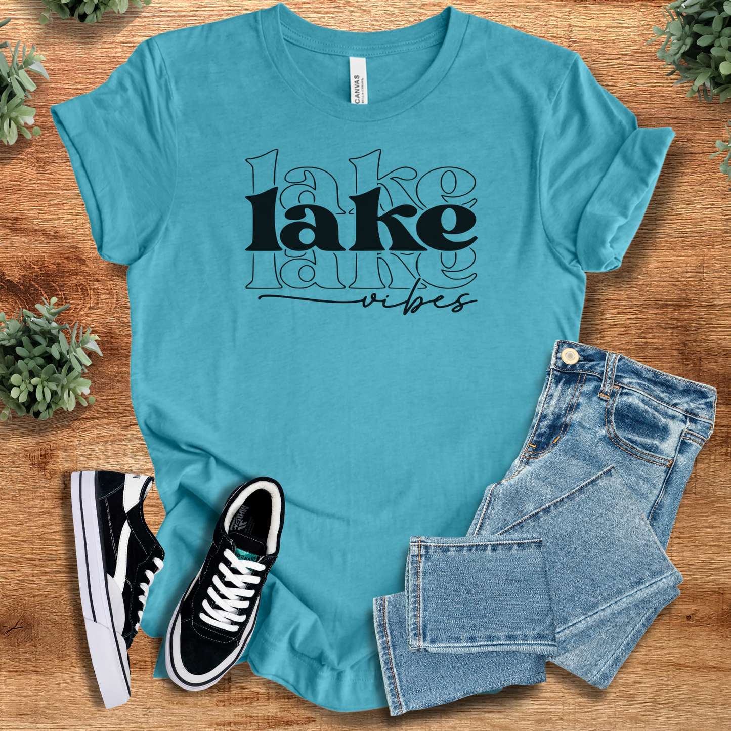 Heather-navy t-shirt with '' text, flat lay styled on a wooden surface.