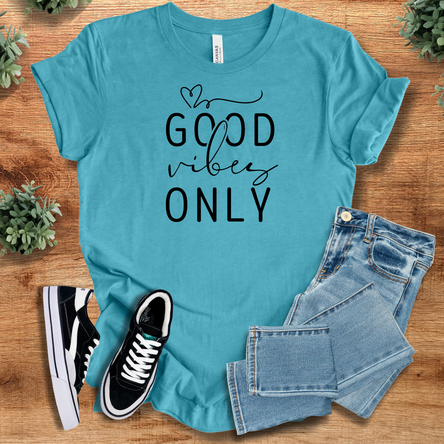 Heather-navy t-shirt with '' text, flat lay styled on a wooden surface.