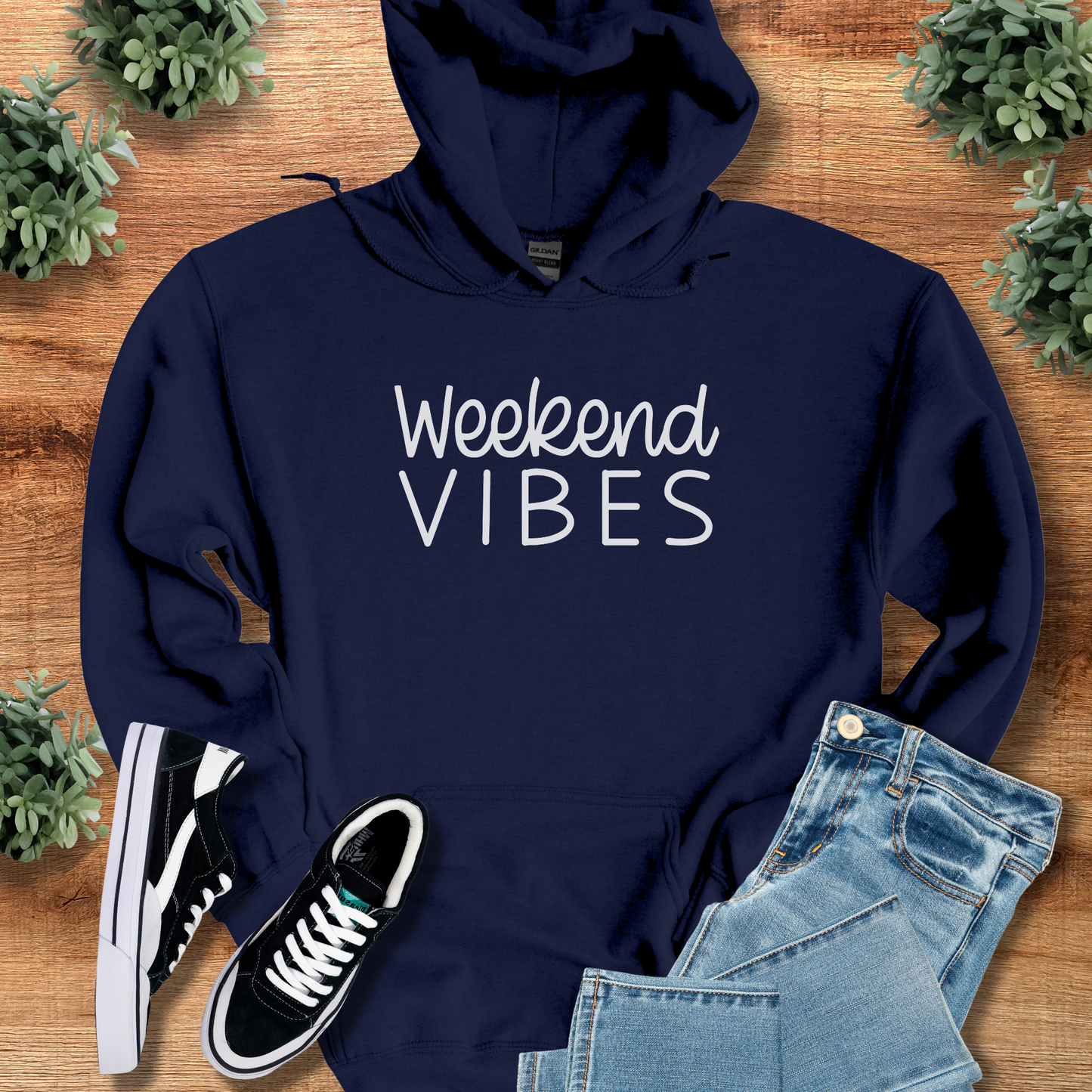 Black t-shirt with '' text, flat lay styled on a wooden surface.