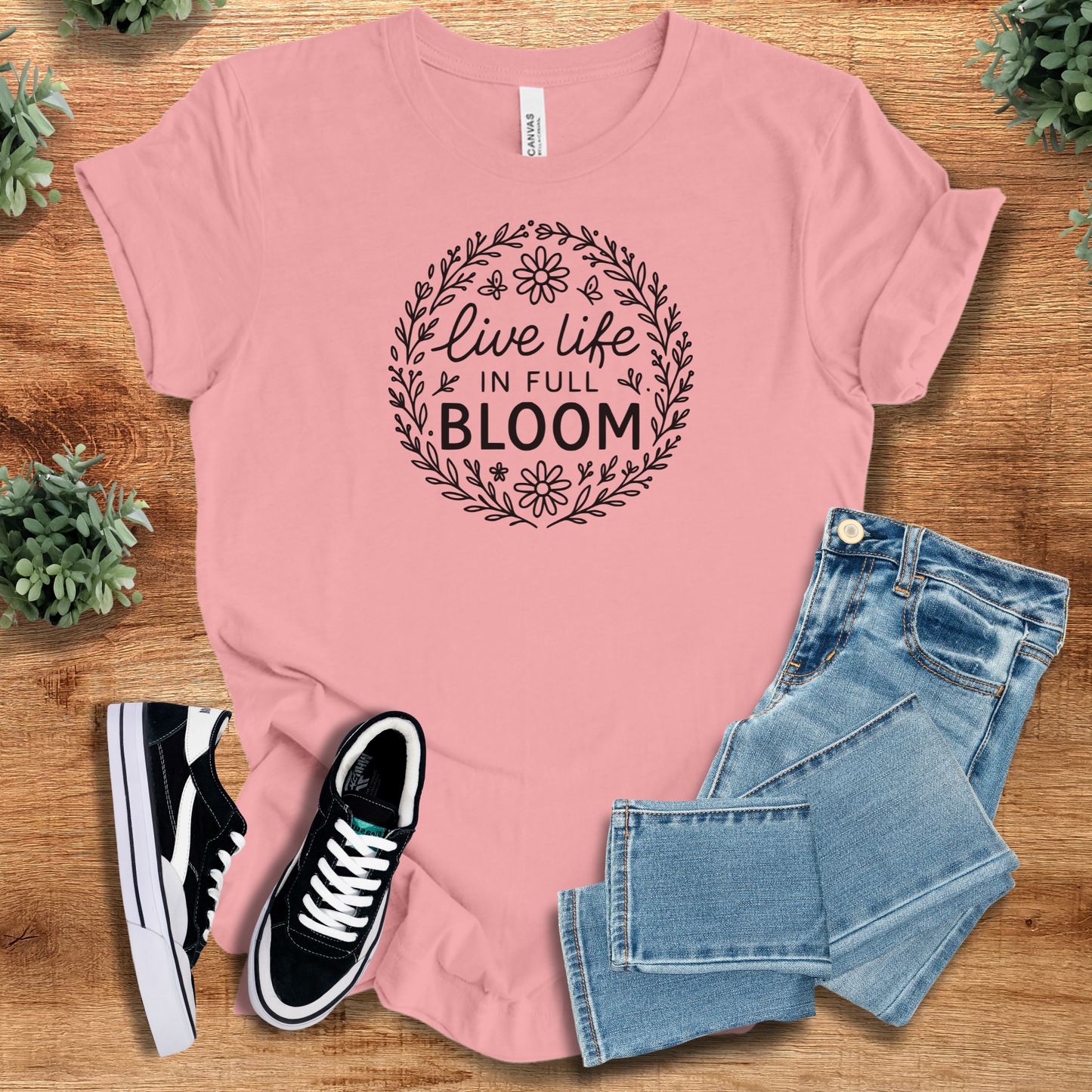Yellow t-shirt with '' text, flat lay styled on a wooden surface.