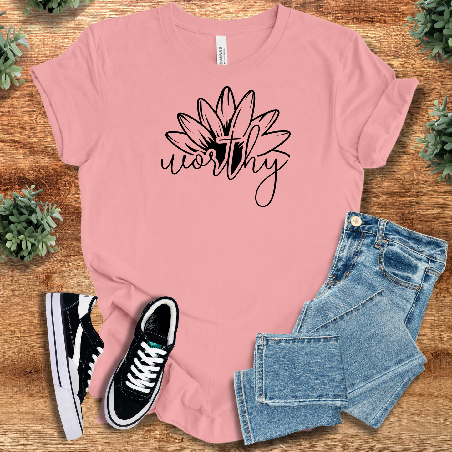 Heather-aqua t-shirt with '' text, flat lay styled on a wooden surface.