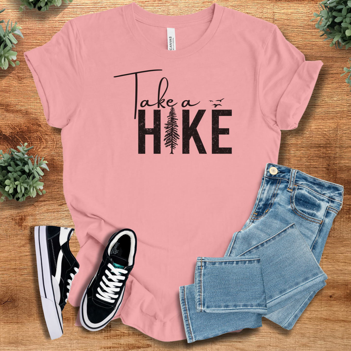Heather-aqua t-shirt with '' text, flat lay styled on a wooden surface.