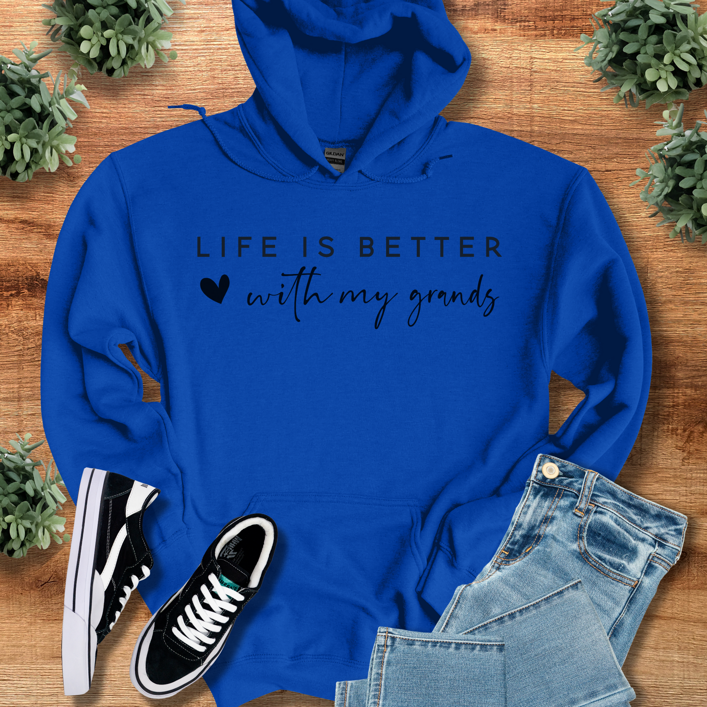 Navy t-shirt with '' text, flat lay styled on a wooden surface.