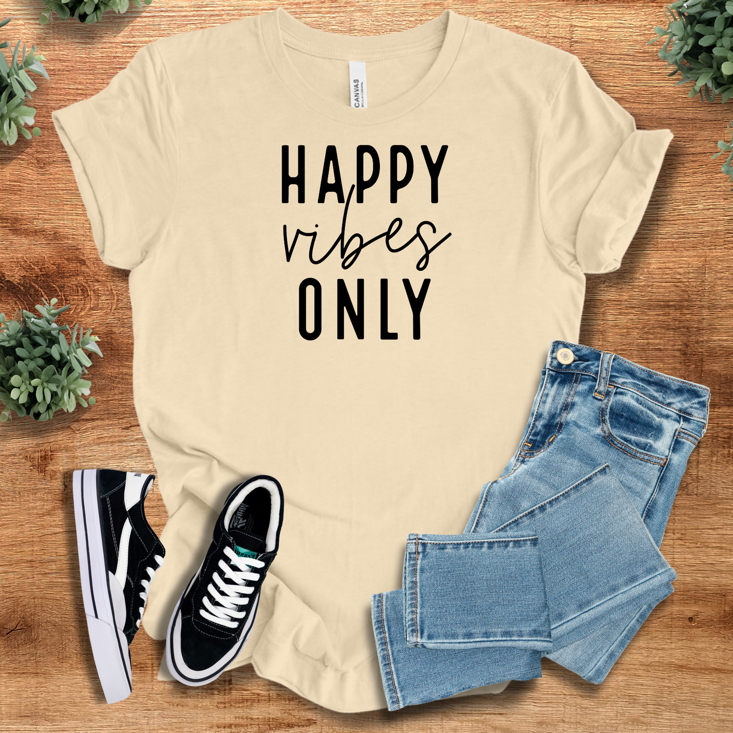 Happy Vibes Only Tee in cream with black text, styled with jeans and sneakers. Cheerful Airlume cotton tee for optimistic and casual fashion.