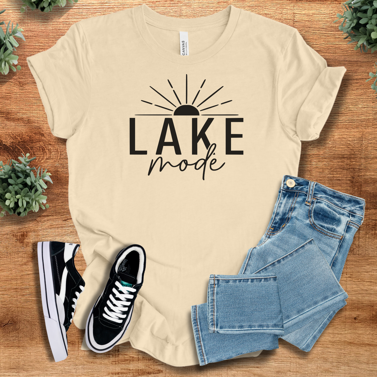 Heather-mauve t-shirt with '' text, flat lay styled on a wooden surface.