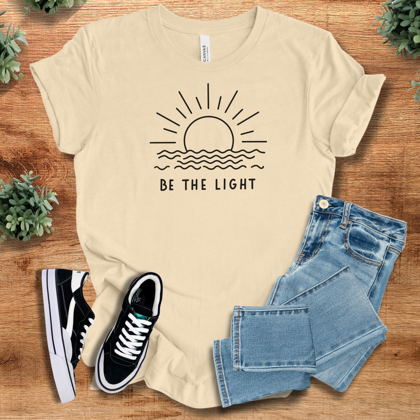 Heather-navy t-shirt with '' text, flat lay styled on a wooden surface.