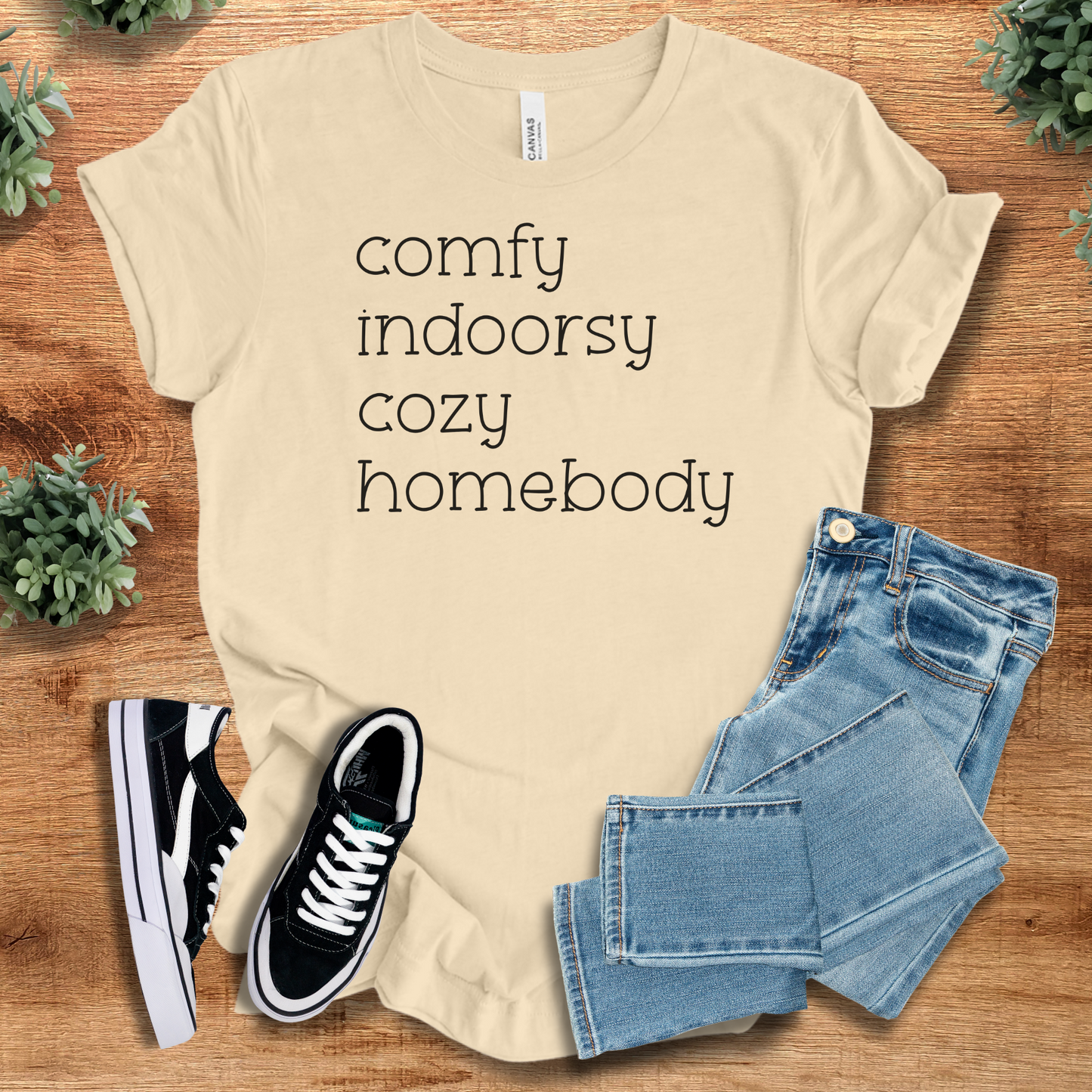 Heather-aqua t-shirt with '' text, flat lay styled on a wooden surface.