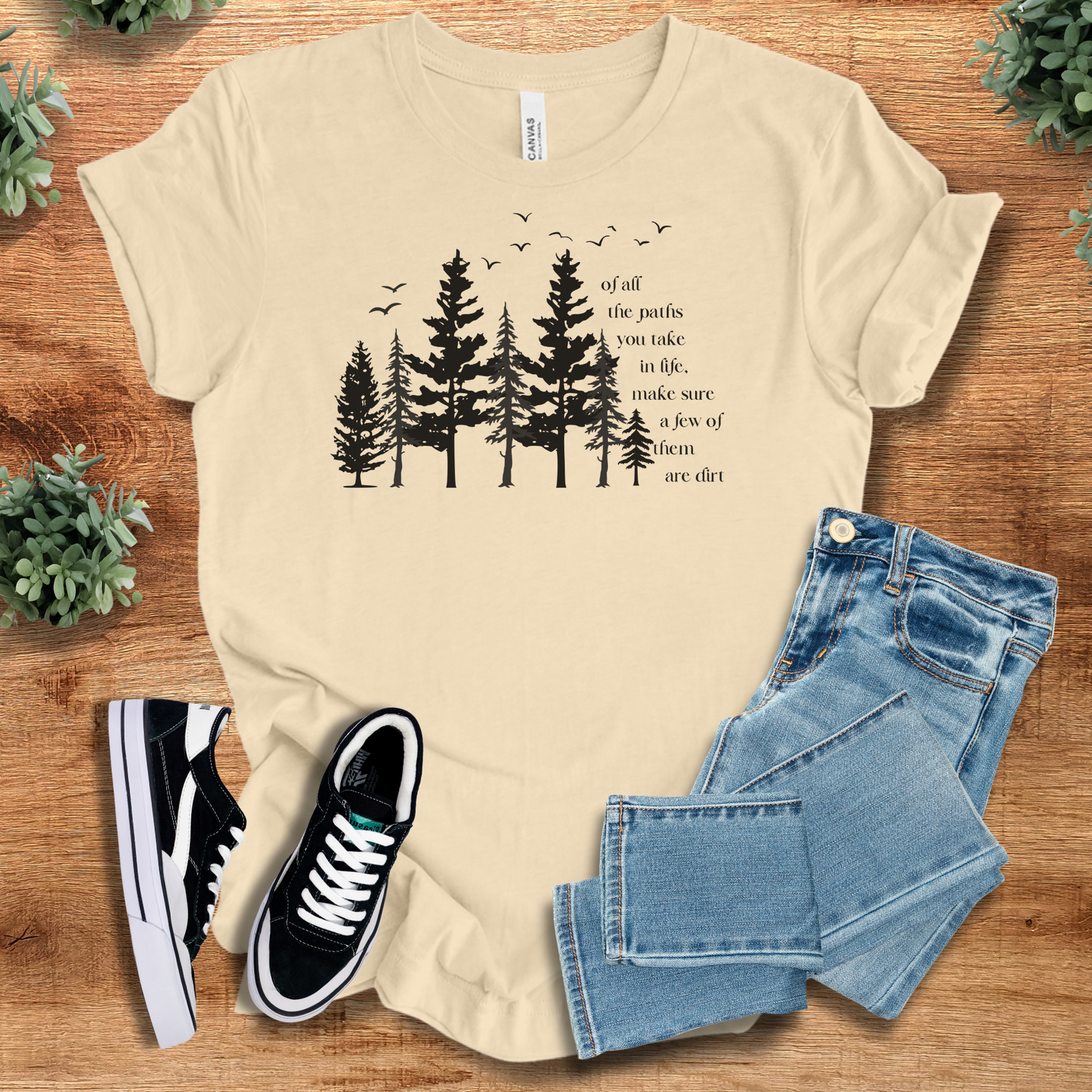 Yellow t-shirt with '' text, flat lay styled on a wooden surface.