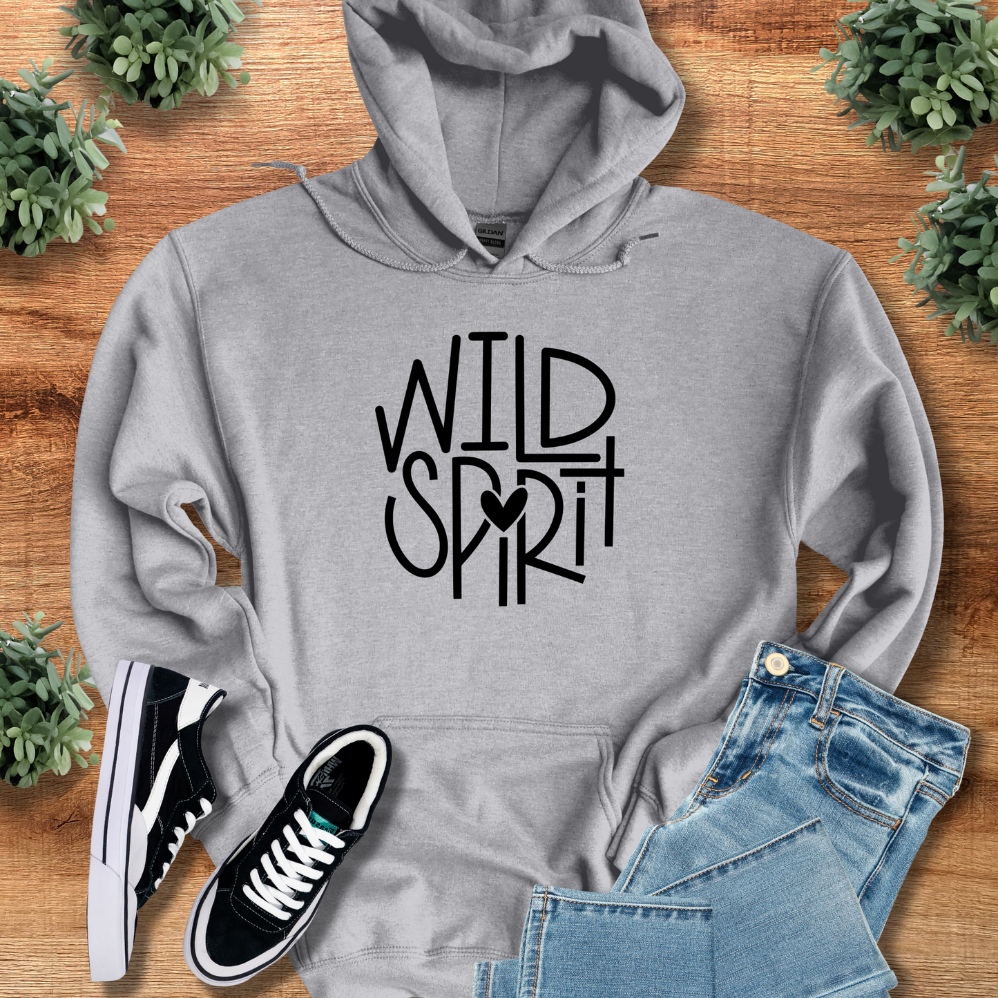 Wild Spirit Hoodie for Outdoor and Casual Wear in heather gray with bold black typography, styled with denim shorts and black sneakers on wood background.