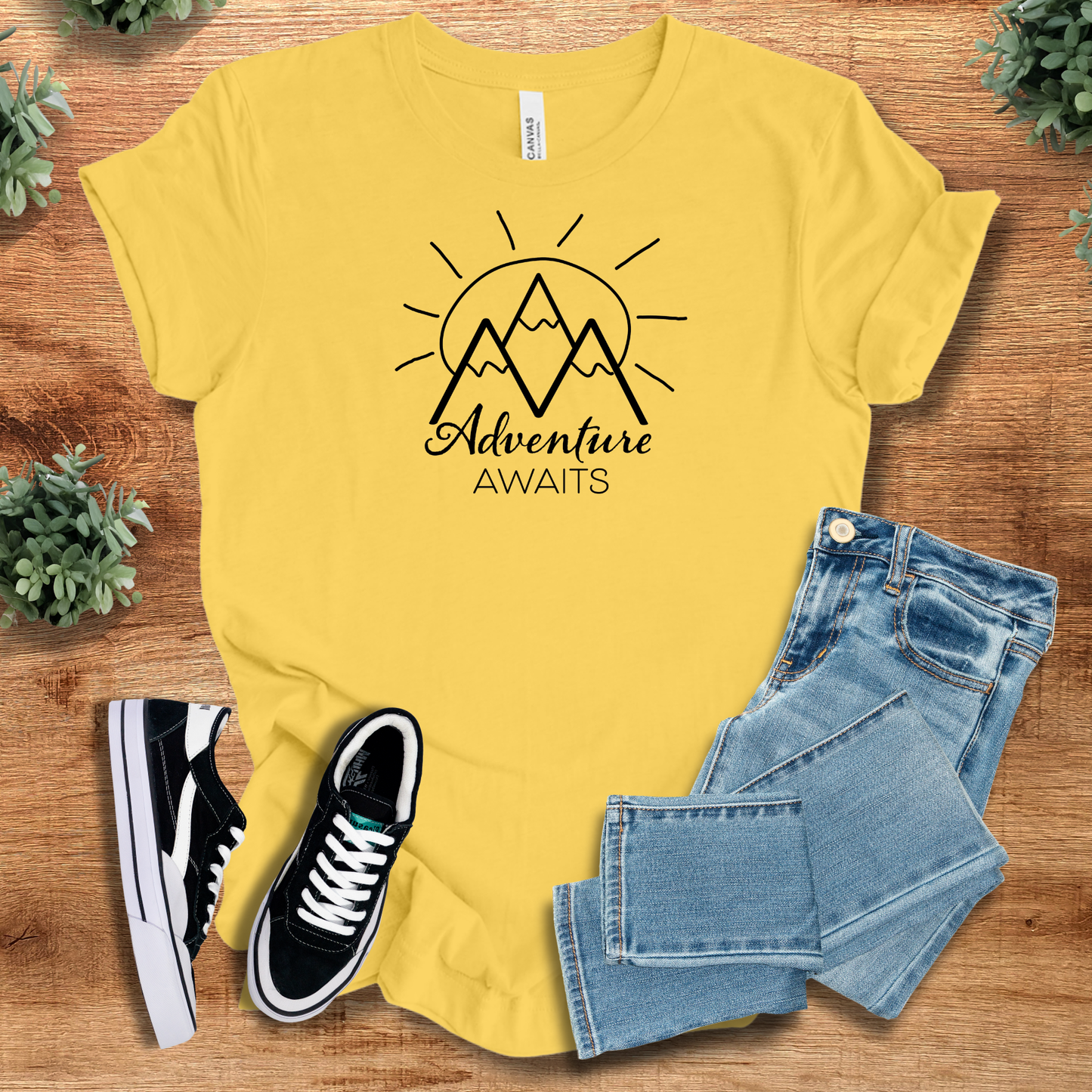 Military-green t-shirt with '' text, flat lay styled on a wooden surface.