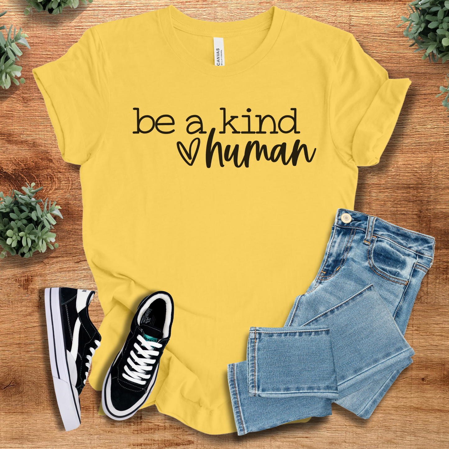 Athletic-heather t-shirt with '' text, flat lay styled on a wooden surface.