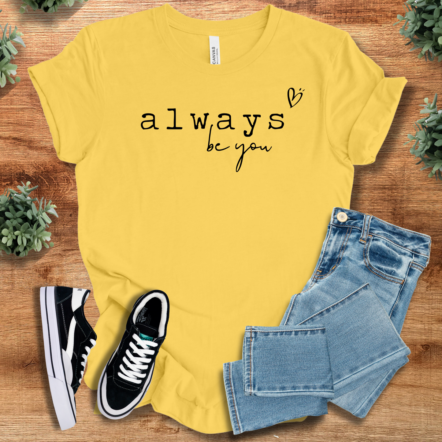 Athletic-heather t-shirt with '' text, flat lay styled on a wooden surface.