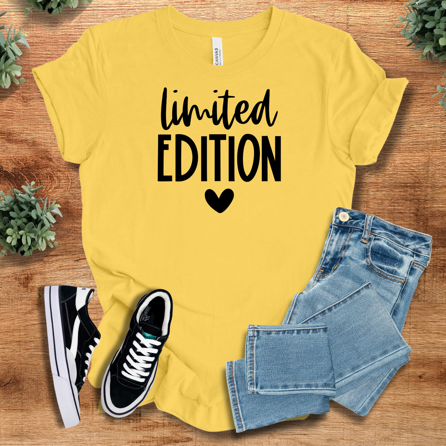 Athletic-heather t-shirt with '' text, flat lay styled on a wooden surface.