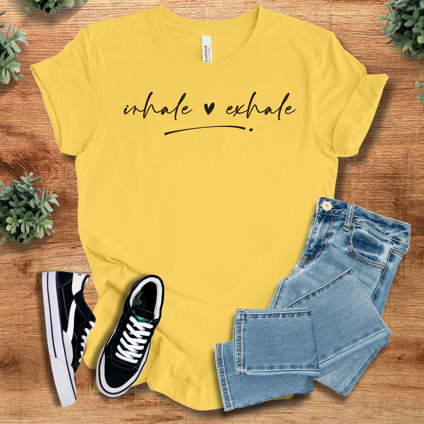 Athletic-heather t-shirt with '' text, flat lay styled on a wooden surface.