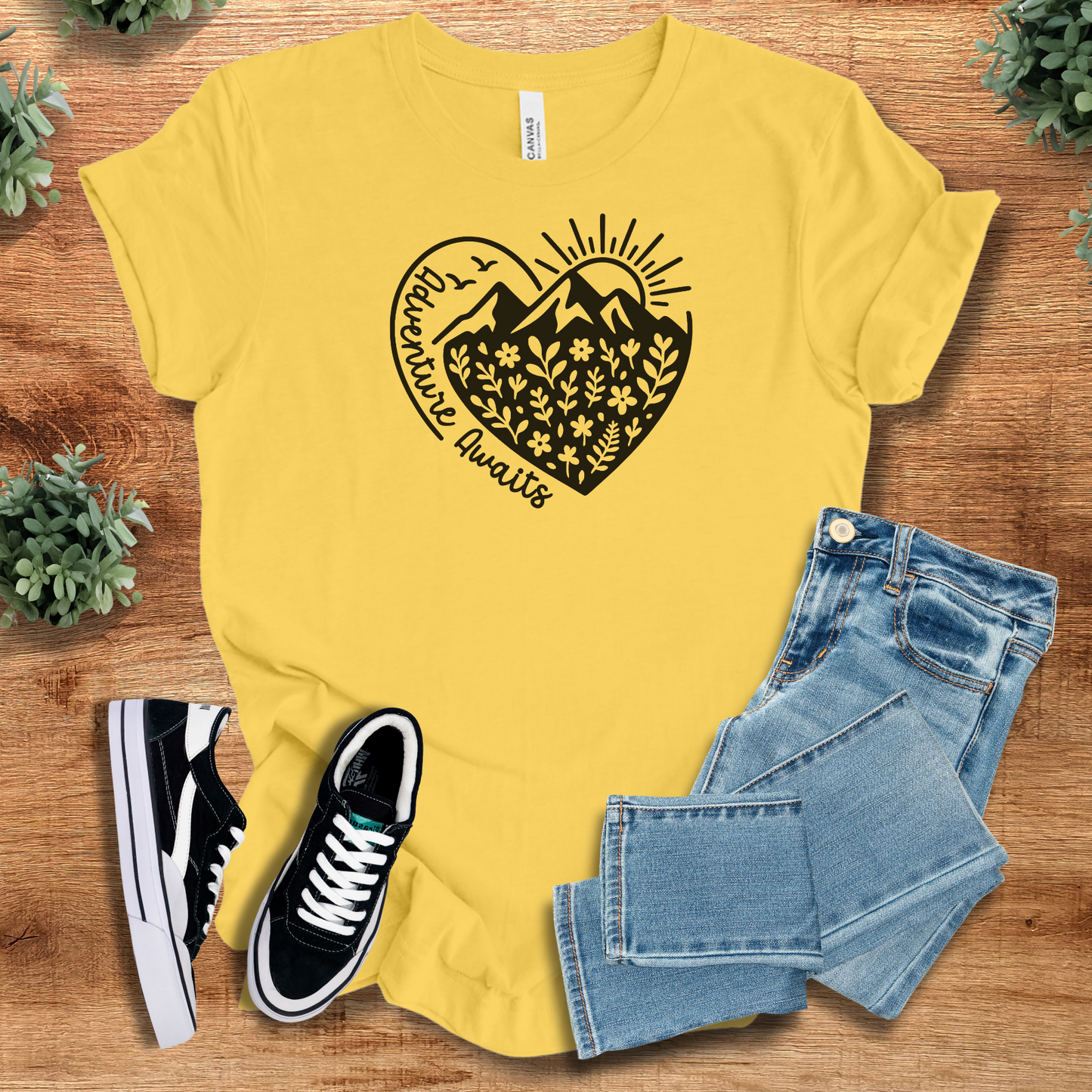 Military-green t-shirt with '' text, flat lay styled on a wooden surface.