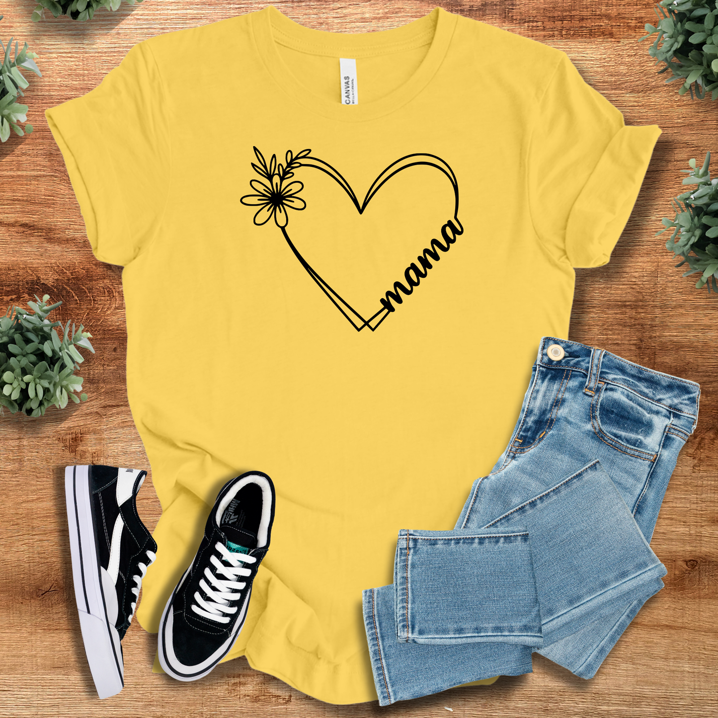 Military-green t-shirt with '' text, flat lay styled on a wooden surface.