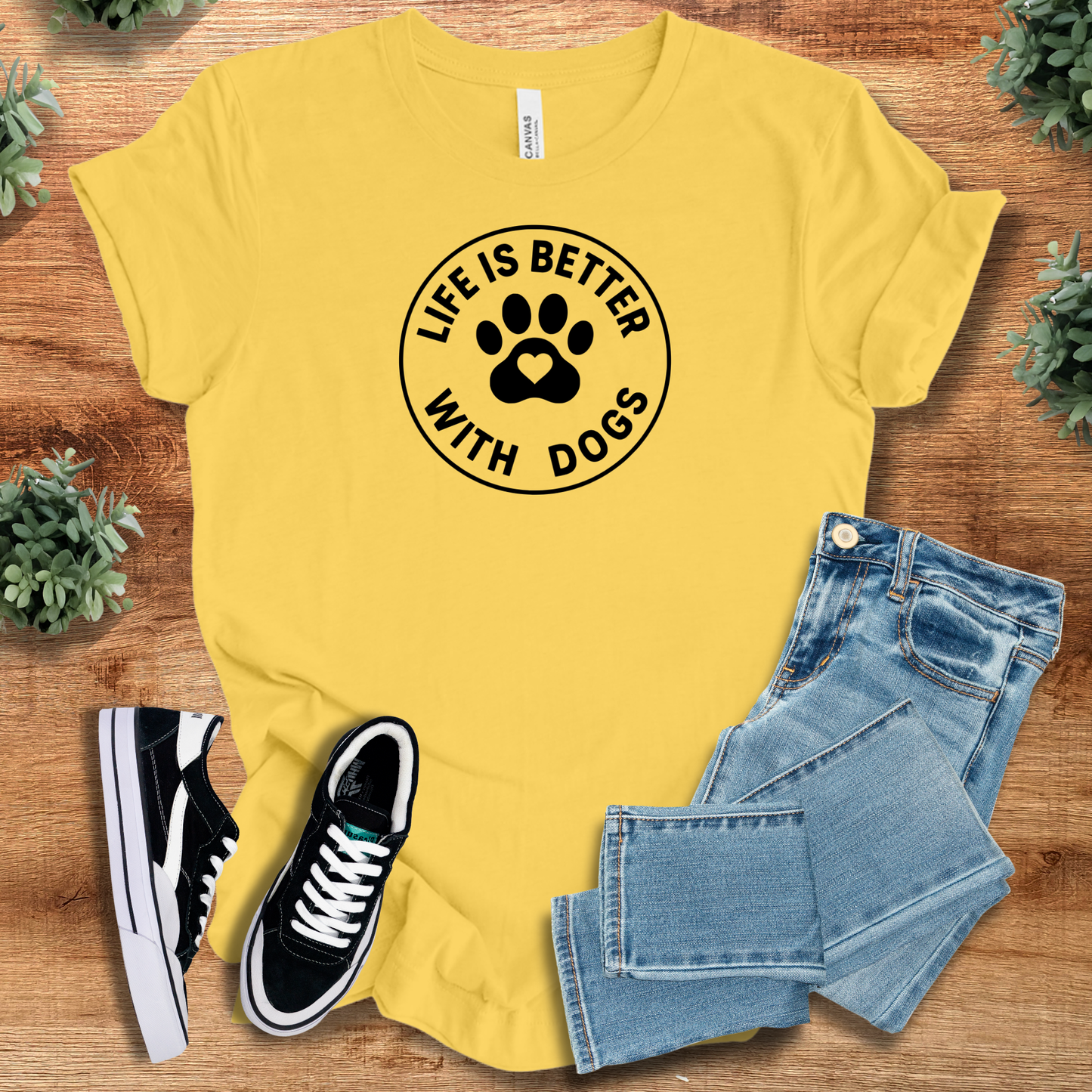 Military-green t-shirt with '' text, flat lay styled on a wooden surface.