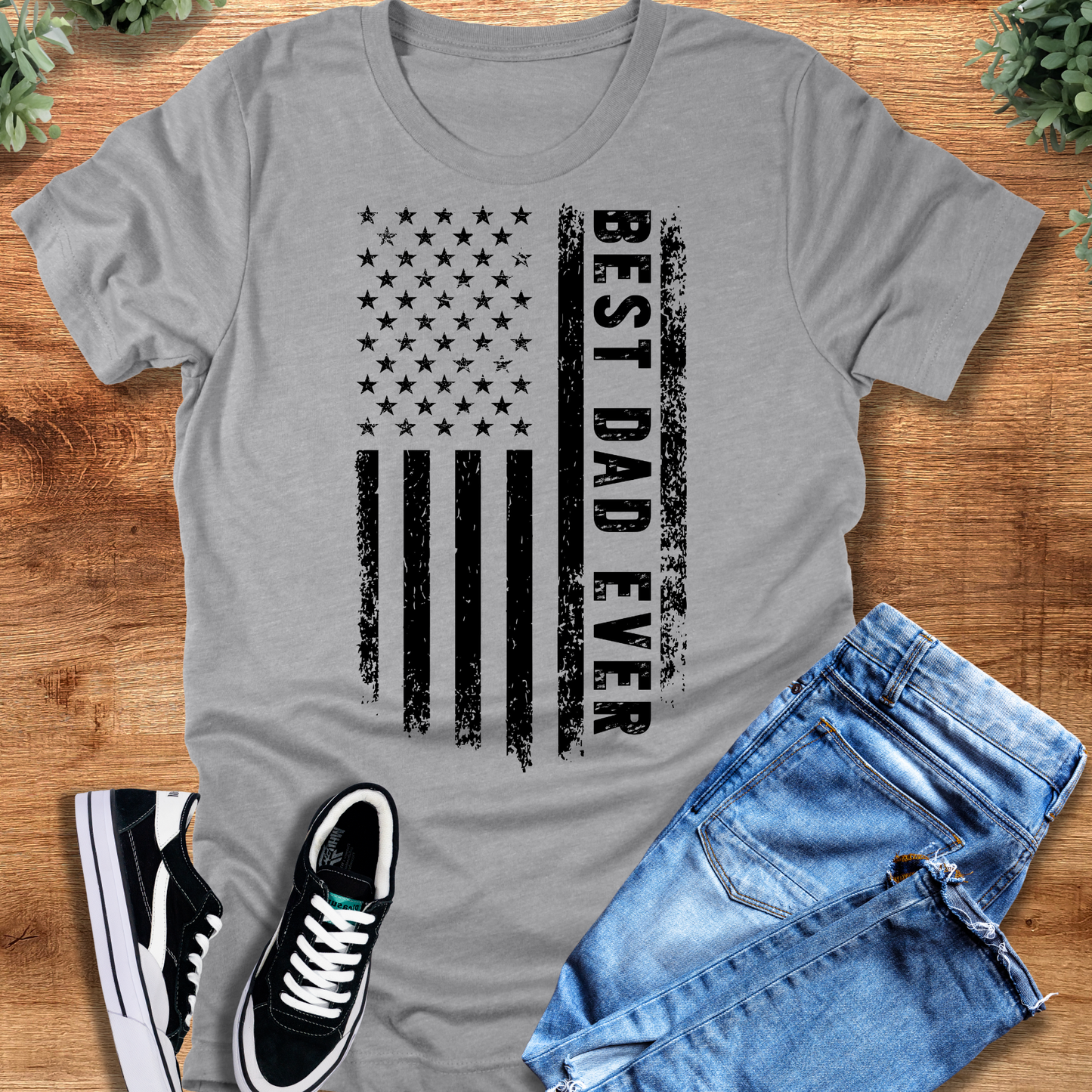 Black t-shirt with '' text, flat lay styled on a wooden surface.