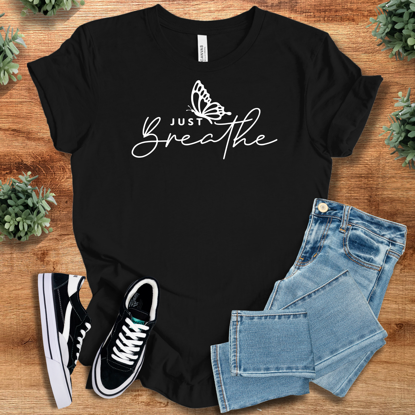 Black Just Breathe Tee T‑Shirt on Bella+Canvas 3001 with white minimalist butterfly graphic, styled with denim and sneakers.