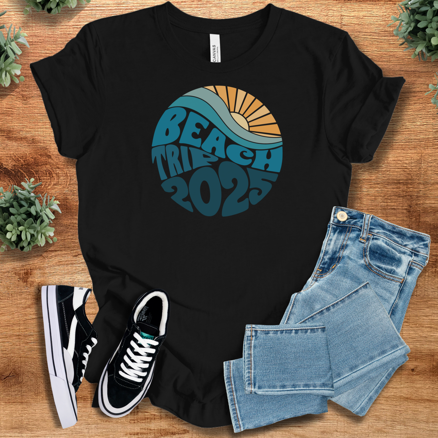 White t-shirt with '' text, flat lay styled on a wooden surface.