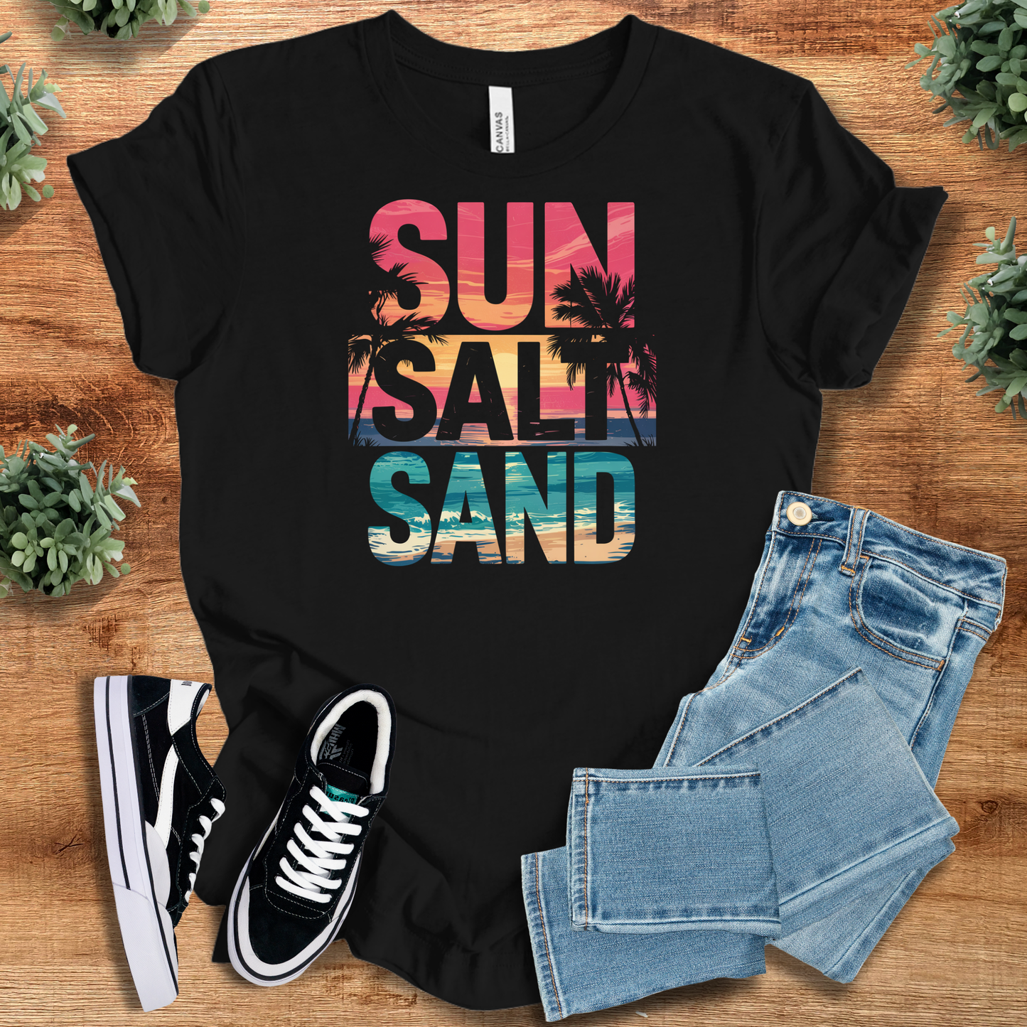 White t-shirt with '' text, flat lay styled on a wooden surface.