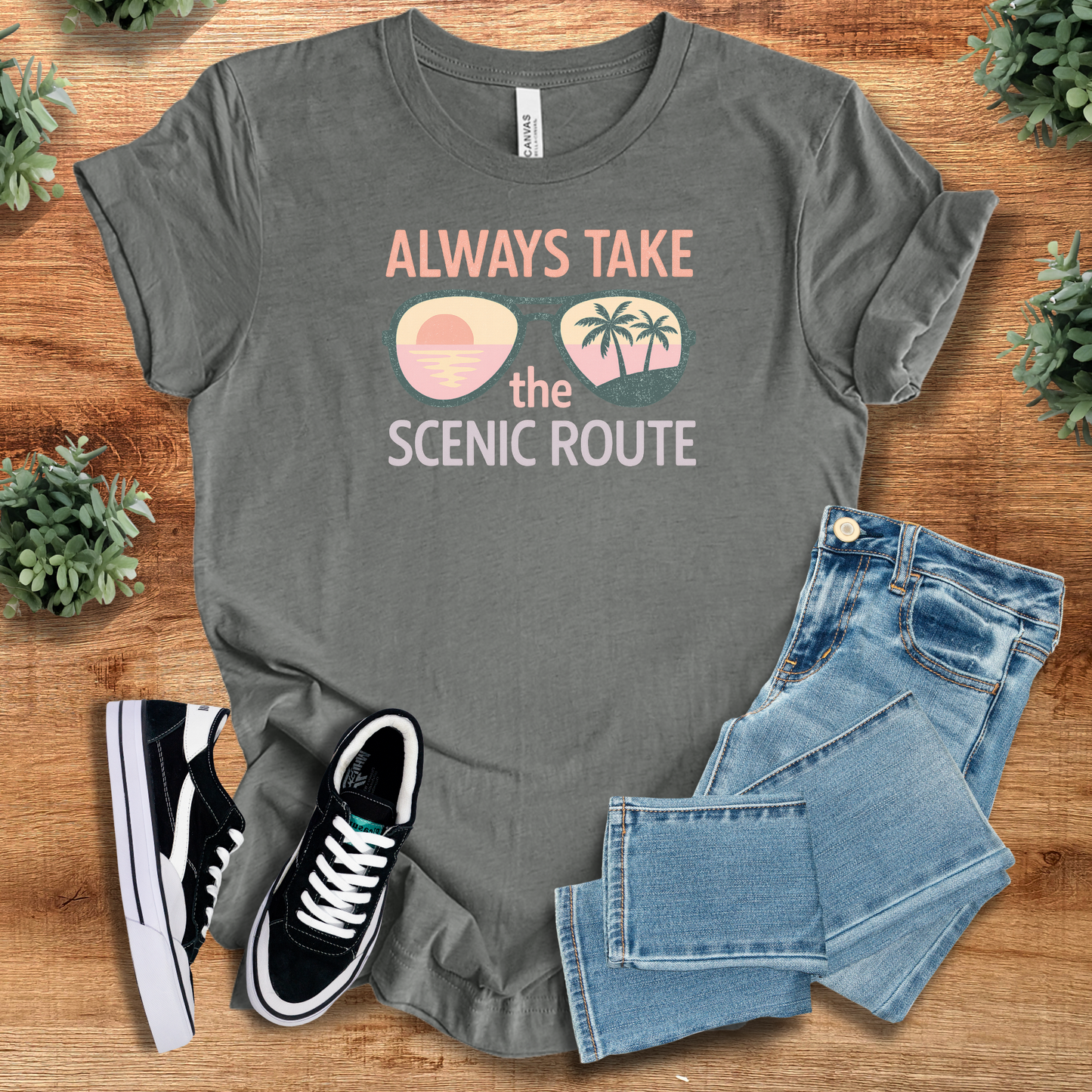 White t-shirt with '' text, flat lay styled on a wooden surface.