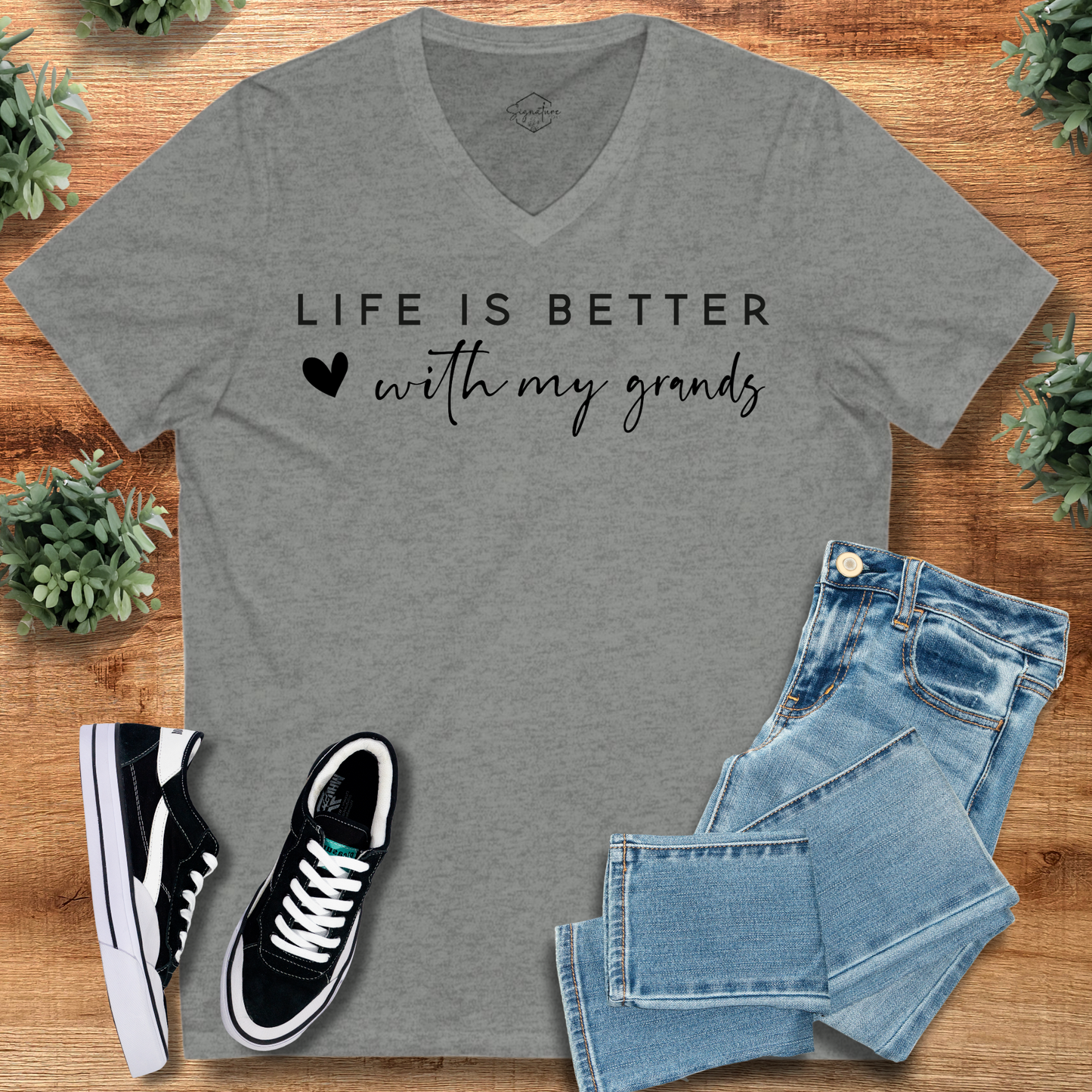 Navy t-shirt with '' text, flat lay styled on a wooden surface.