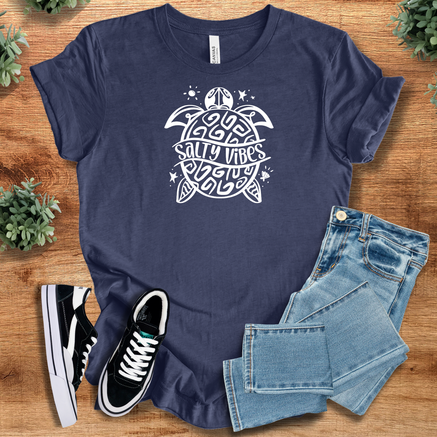 Heather-aqua t-shirt with '' text, flat lay styled on a wooden surface.