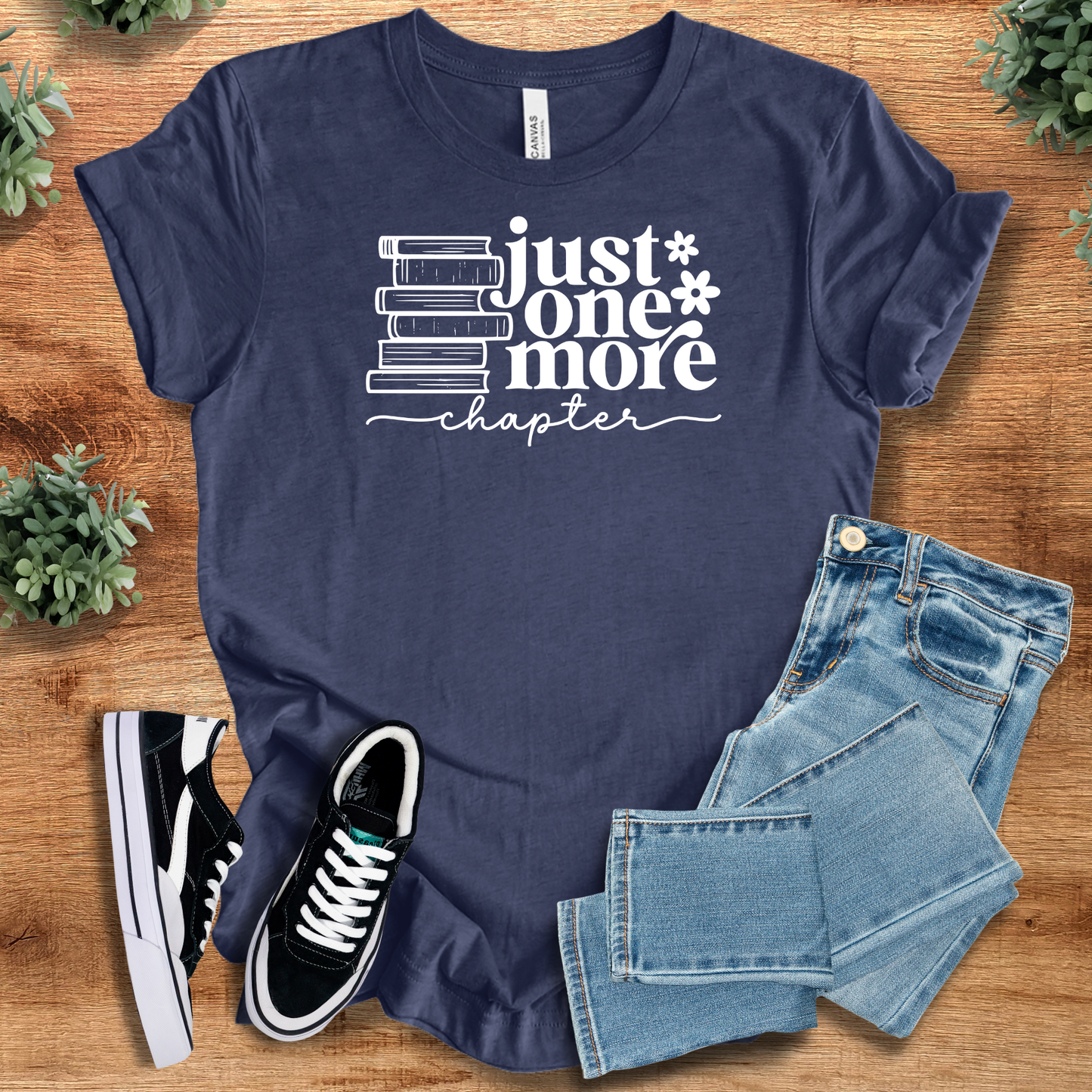 Navy blue 'Just One More Chapter' unisex t-shirt featuring book stack graphic. Perfect literary gift for readers and bookworms.