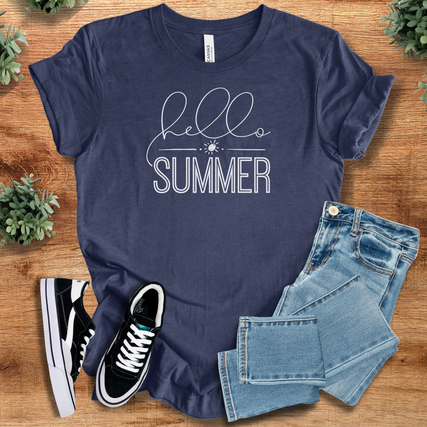 Yellow t-shirt with '' text, flat lay styled on a wooden surface.