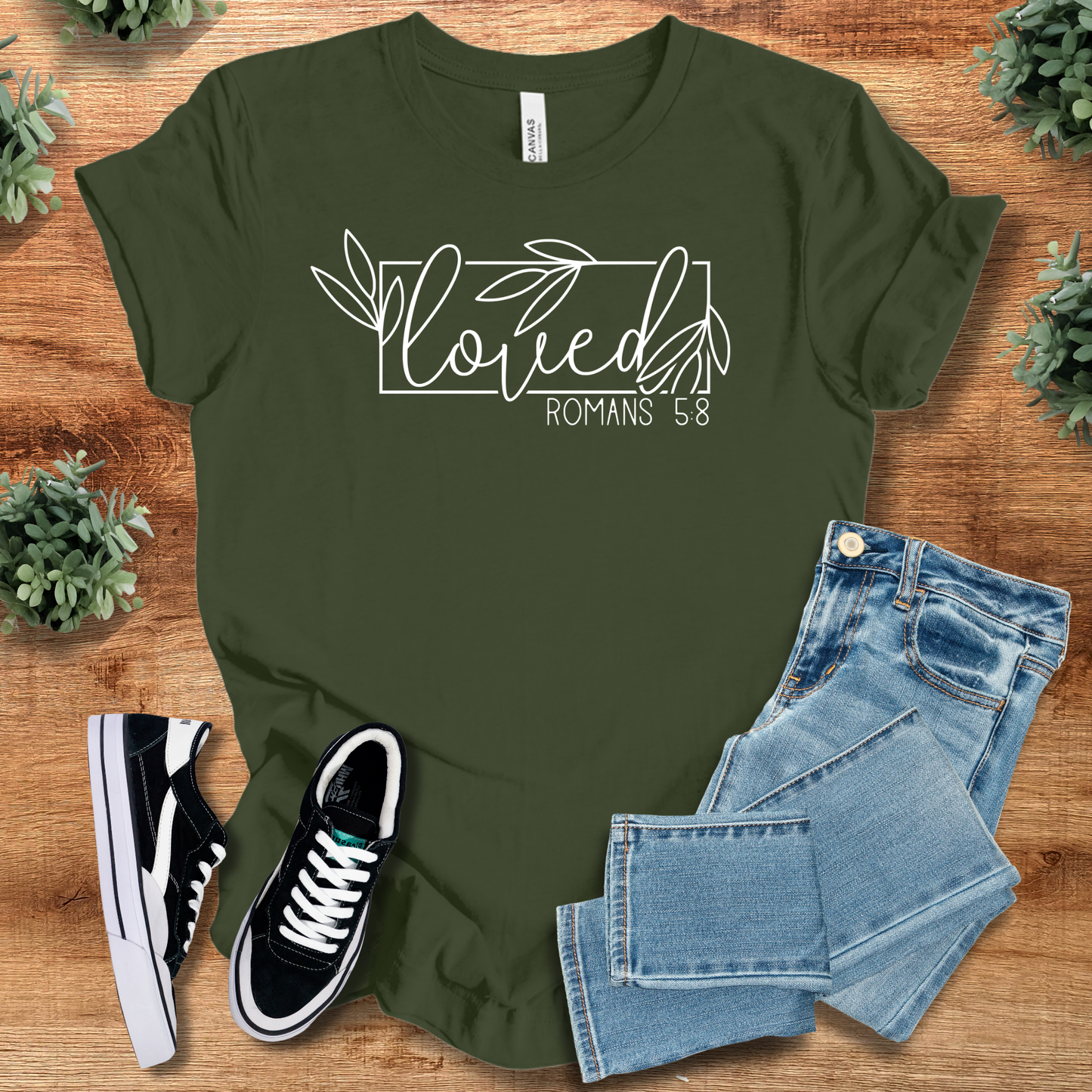 Olive green Loved Romans 5:8 Christian T-Shirt featuring faith-inspired script, styled for casual wear with jeans and sneakers.