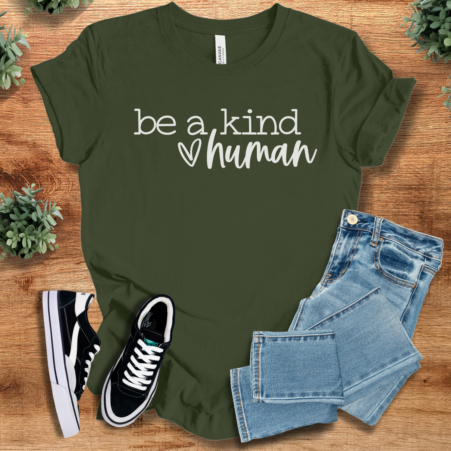 Heather-navy t-shirt with '' text, flat lay styled on a wooden surface.