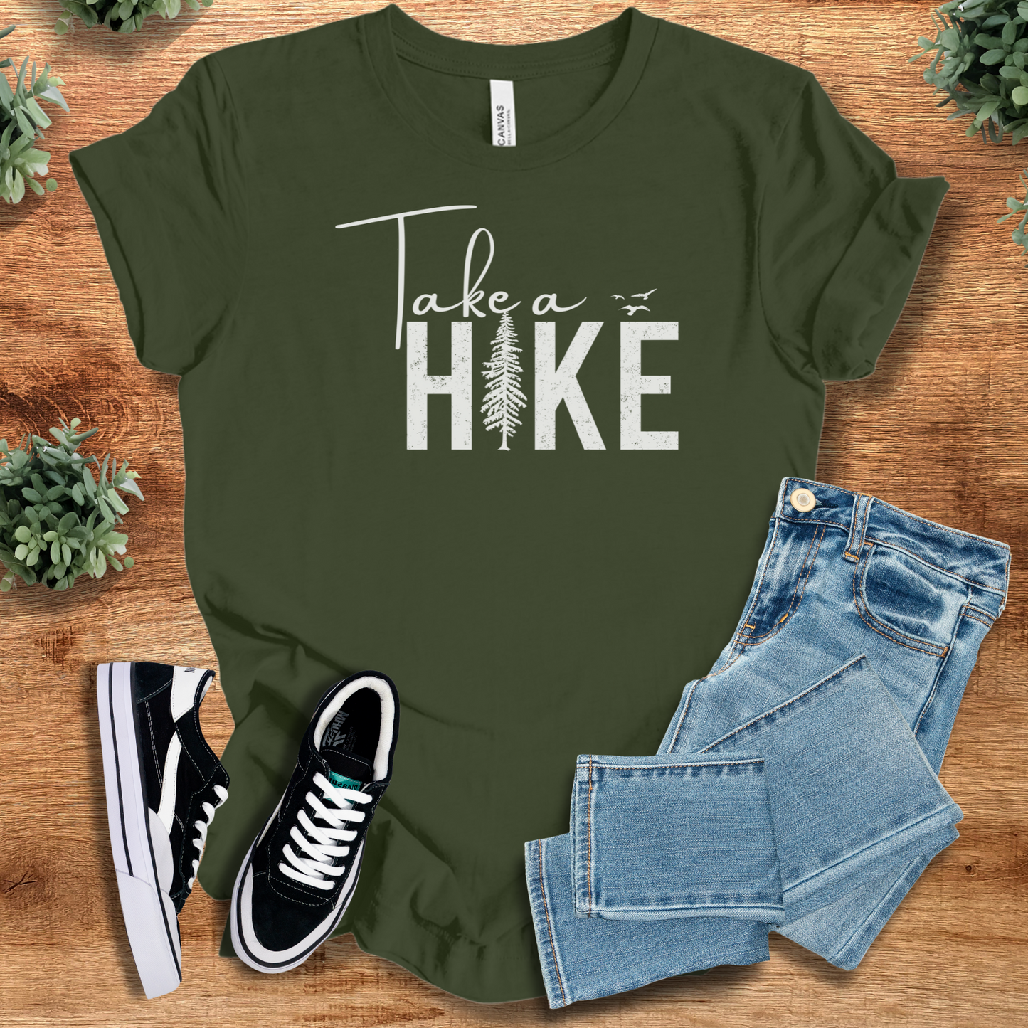 Yellow t-shirt with '' text, flat lay styled on a wooden surface.